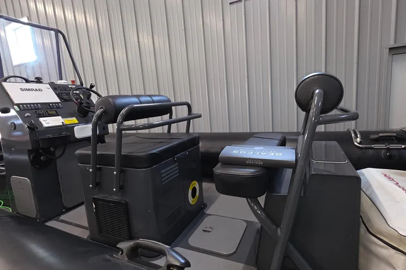 Slide: The Image of 2019 Sealegs 7.1 RIB interior with Simrad console and seating in a metal-walled storage area. - 14