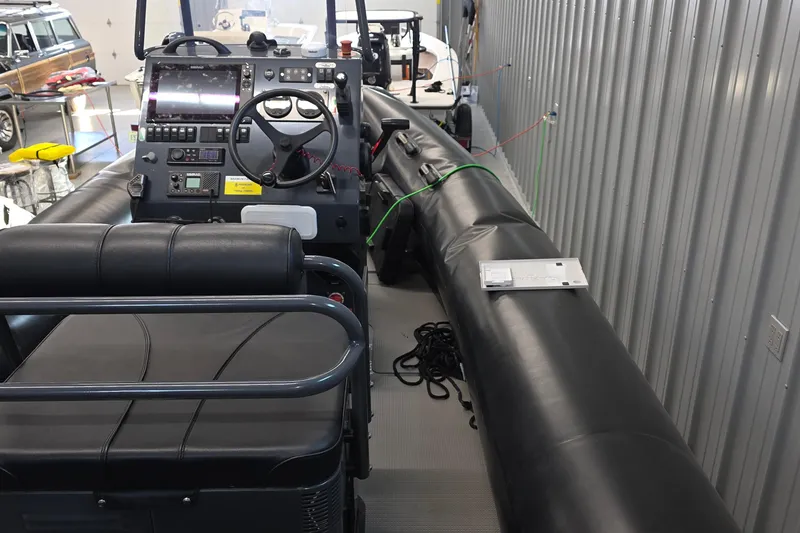 Slide: The Image of 2019 Sealegs 7.1 RIB interior with steering console and seating in a garage setting. - 15