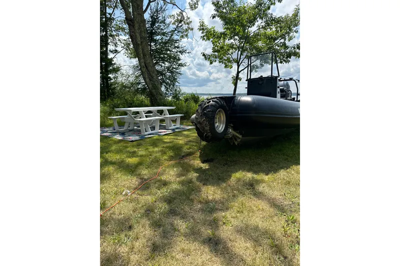 Slide: The Image of 2019 Sealegs 7.1 RIB on grassy area near picnic table and trees. - 4