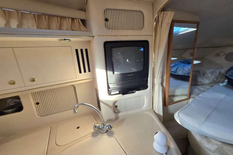 Slide: The Image of Interior of 1999 Sea Ray 340 Sundancer with TV, sink, and cozy sleeping area. - 12