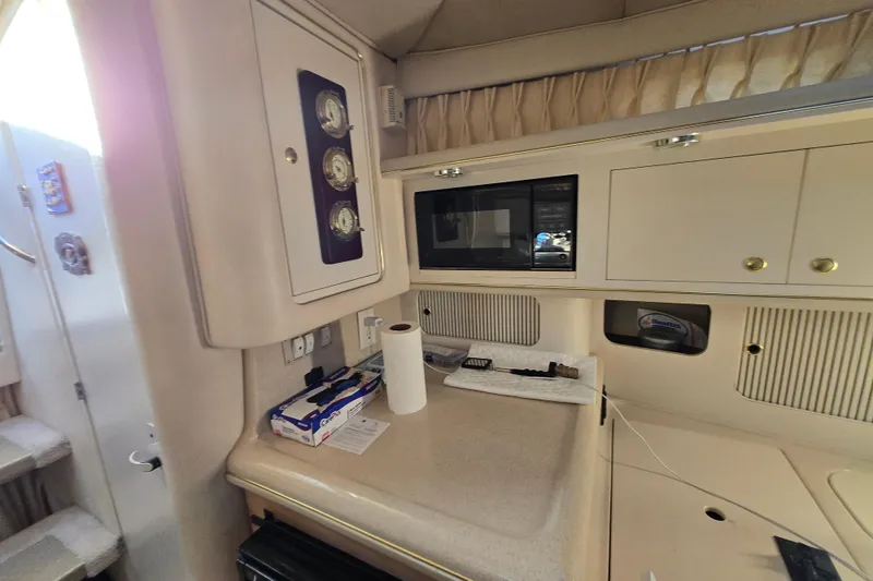 Slide: The Image of 1999 Sea Ray 340 Sundancer cabin interior with kitchenette and microwave. - 13