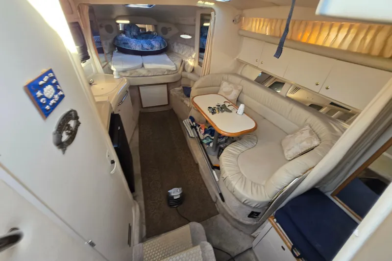 Slide: The Image of Interior of 1999 Sea Ray 340 Sundancer yacht with cozy seating and sleeping area. - 18