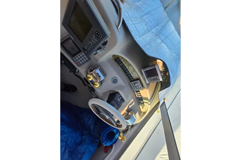Slide: The Image of 1999 Sea Ray 340 Sundancer helm with steering wheel and navigation instruments. - 22