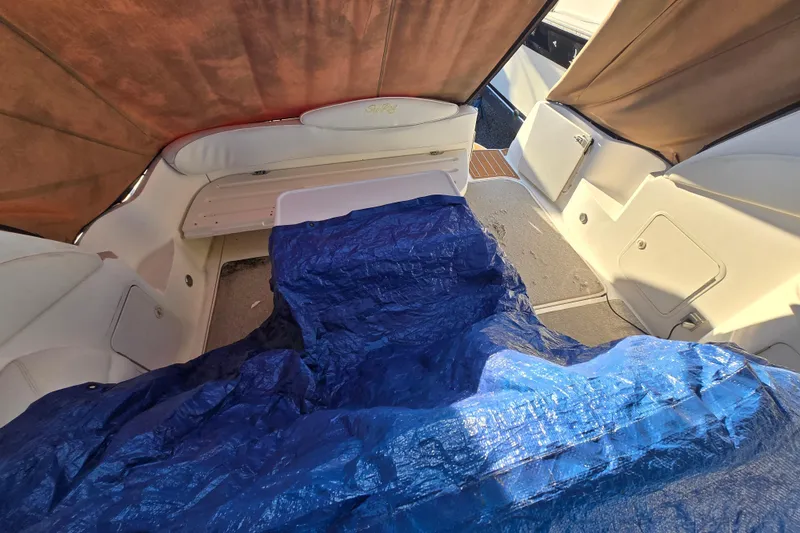 Slide: The Image of Interior of a 1999 Sea Ray 340 Sundancer with blue tarp covering seating area. - 23