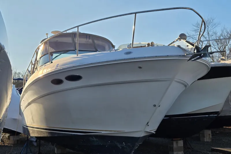 Slide: The Image of 1999 Sea Ray 340 Sundancer boat on dry dock, side view, under clear sky. - 25