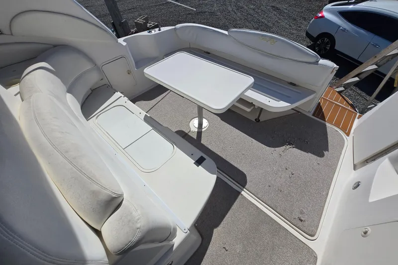 Slide: The Image of 1999 Sea Ray 340 Sundancer cockpit with seating and table, showcasing spacious design. - 26