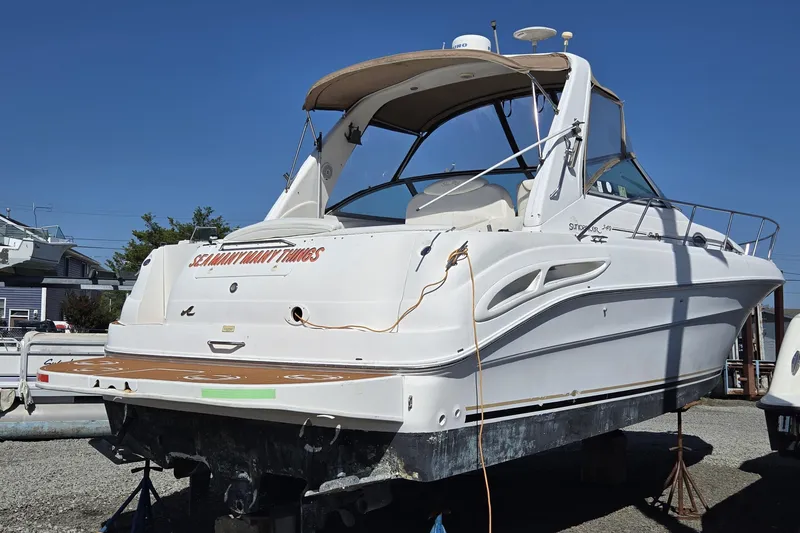 Slide: The Image of 1999 Sea Ray 340 Sundancer boat on dry dock under clear blue sky. - 4