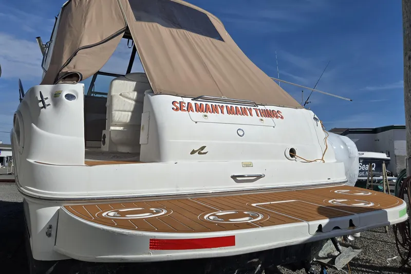Slide: The Image of 1999 Sea Ray 340 Sundancer boat with tan canopy and custom lettering on the stern. - 7