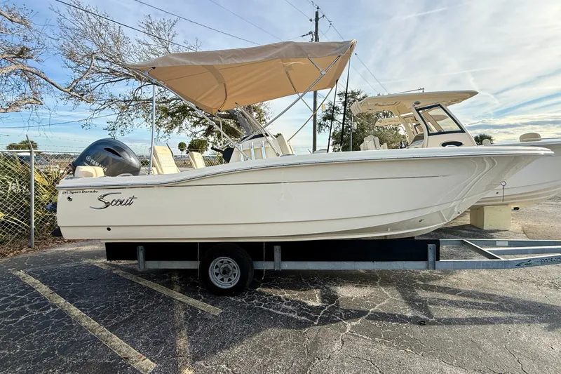 The Image of 2026 Scout 195 Sport Dorado boat on trailer with canopy, parked outdoors. - 0