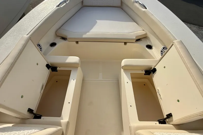 Slide: The Image of 2026 Scout 195 Sport Dorado boat interior with open storage compartments and cushioned seating. - 12