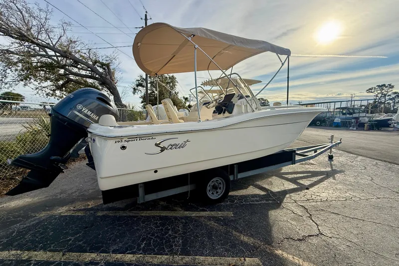 Slide: The Image of 2026 Scout 195 Sport Dorado boat on trailer with Yamaha engine, under sunny sky. - 2