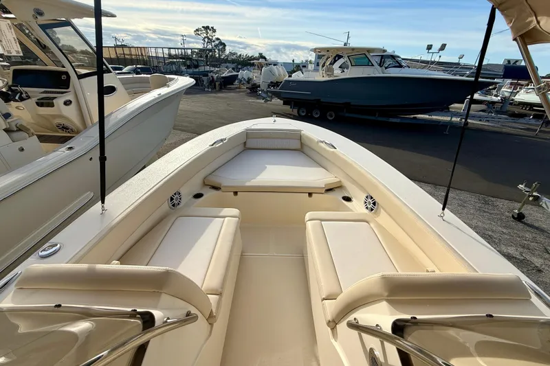 Slide: The Image of 2026 Scout 195 Sport Dorado boat interior with beige seating, docked at a marina. - 8