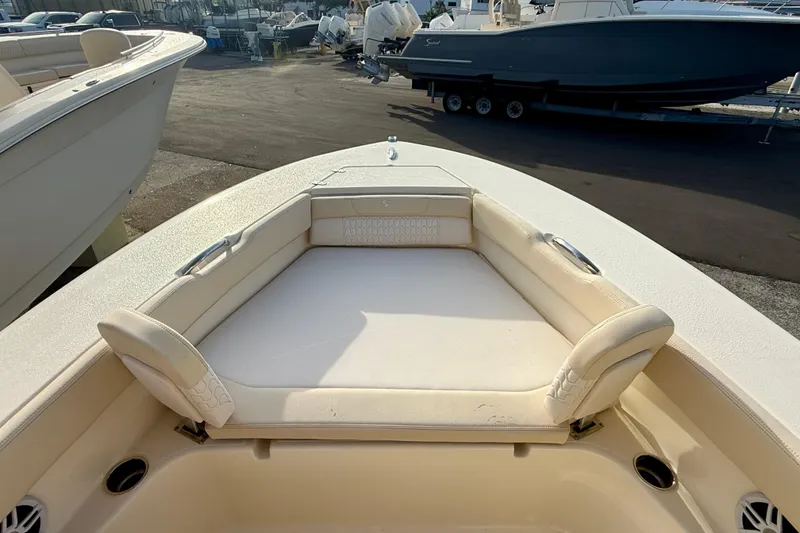 Slide: The Image of 2026 Scout 195 Sport Dorado boat with cushioned seating area, docked outdoors. - 9