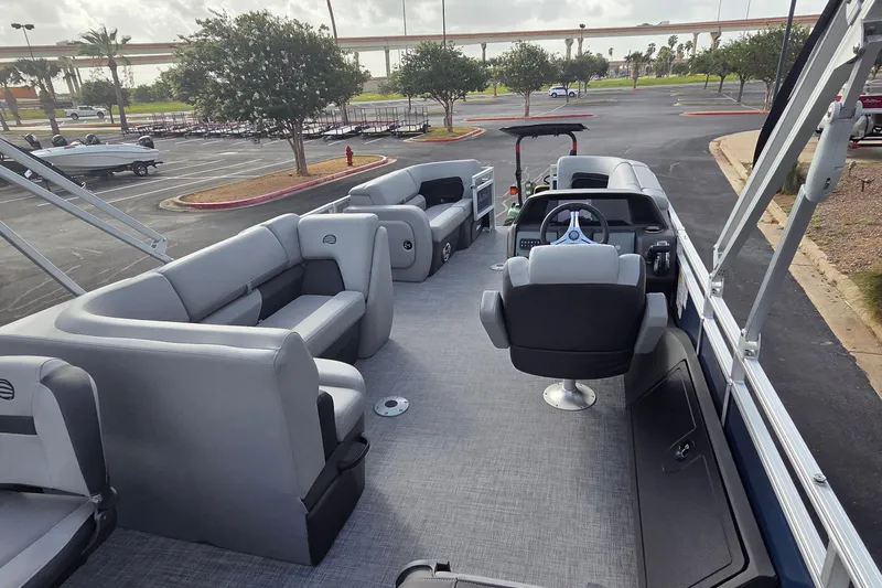 Slide: The Image of 2026 Sun Tracker SportFish 22 DLX pontoon boat interior with seating and steering console. - 8