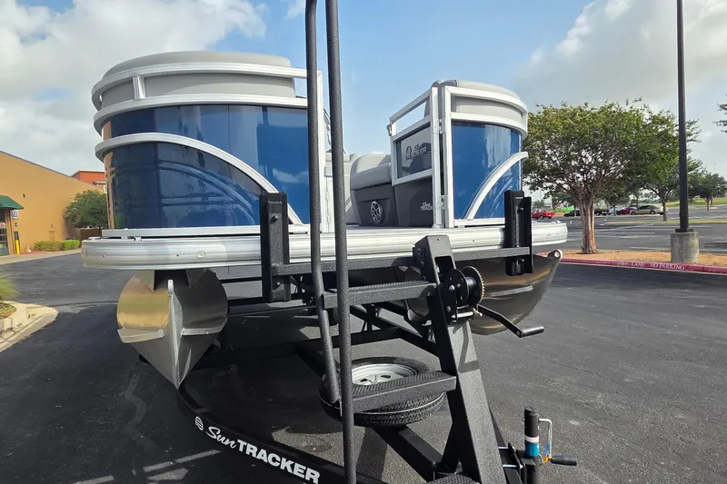 Slide: The Image of 2026 Sun Tracker SportFish 22 DLX pontoon boat on trailer in parking lot. - 7