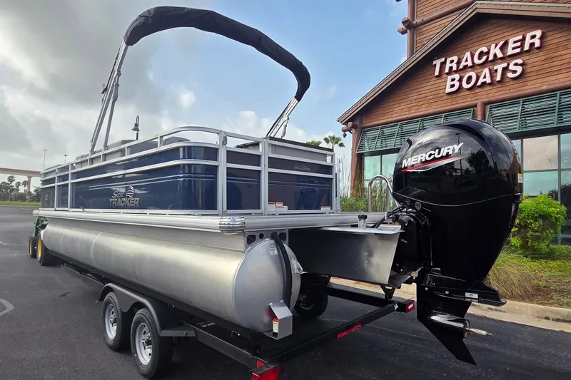 Slide: The Image of 2026 Sun Tracker SportFish 22 DLX pontoon boat with Mercury engine at Tracker Boats dealership. - 3
