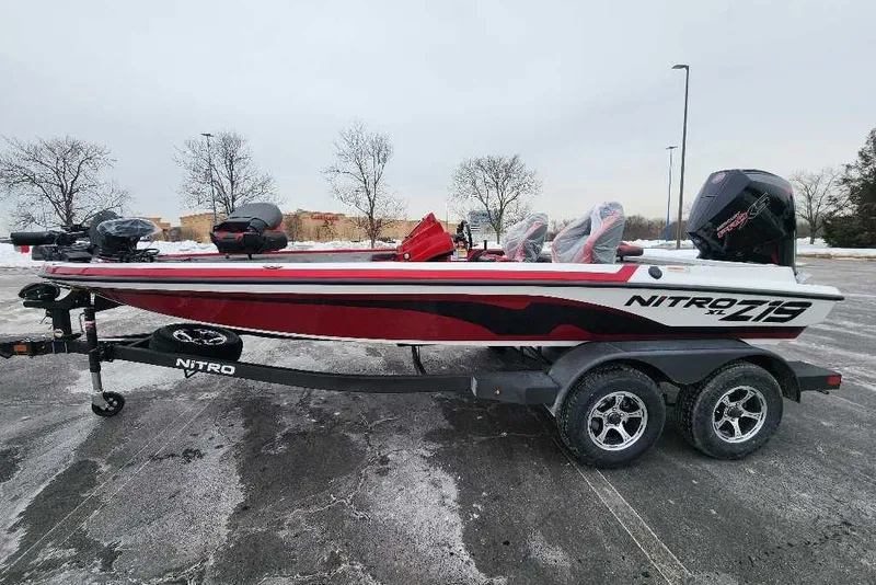 The Image of 2026 Nitro Z19 XL Pro boat on trailer, red and white design, parked outdoors. - 0
