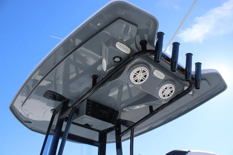 Slide: The Image of Tidewater 220 LXF 2026 boat T-top with speakers and rod holders against blue sky. - 16
