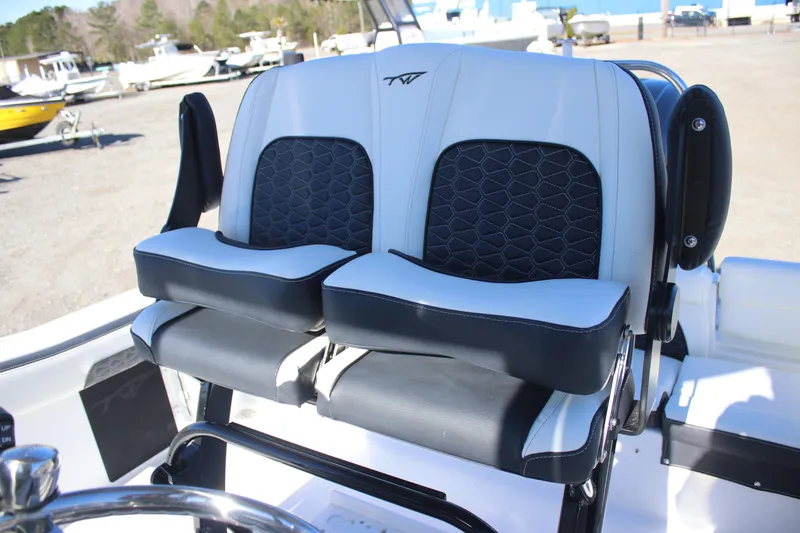 Slide: The Image of 2026 Tidewater 220 LXF boat seats with black and white upholstery in a marina setting. - 6