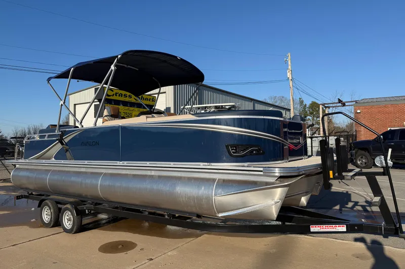 The Image of 2026 Avalon LSZ Quad Lounger Shift pontoon boat on trailer, parked outdoors. - 0