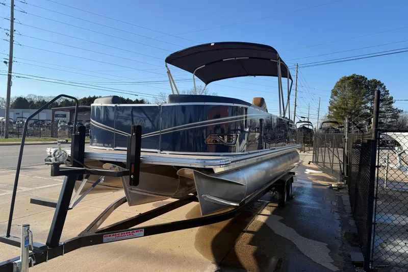 Slide: The Image of 2026 Avalon LSZ Quad Lounger Shift pontoon boat on trailer, sunny day. - 3
