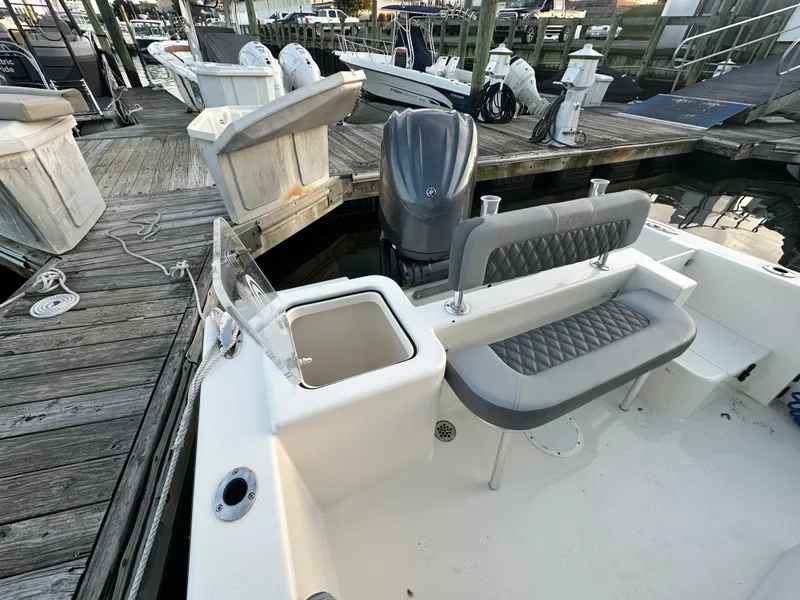 Slide: The Image of Defiance 240 Catalina 2024 boat at dock with seating and motor. - 16