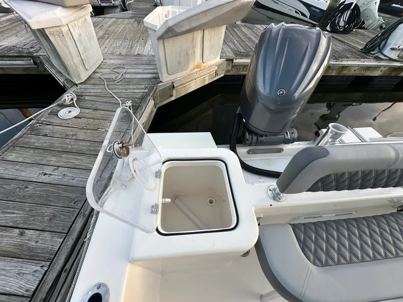 Slide: The Image of Defiance 240 Catalina 2024 with open storage compartment at dock. - 18