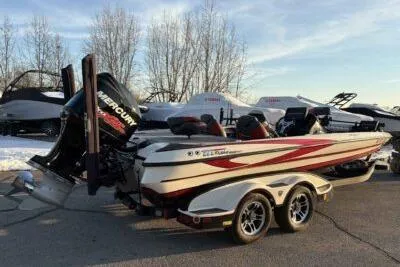 Slide: The Image of 2015 Triton 22 TrX boat with Mercury engine on trailer, parked outdoors. - 2