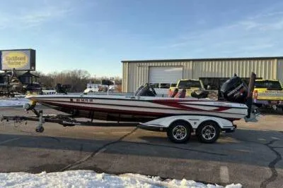 Slide: The Image of 2015 Triton 22 TrX boat on trailer, parked outside a warehouse in winter. - 3