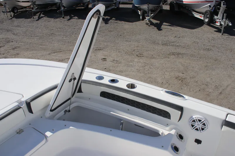 Slide: The Image of 2026 Tidewater 2300 Carolina Bay boat interior with open storage compartment and speaker. - 13