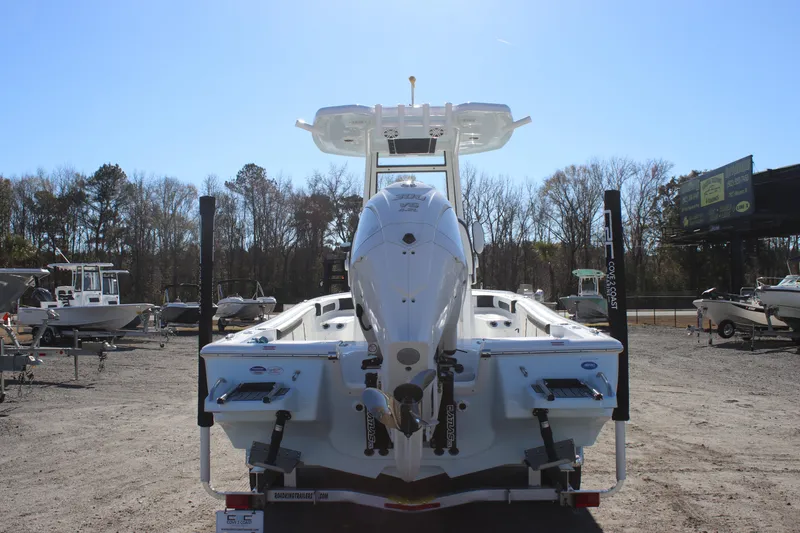 Slide: The Image of 2026 Tidewater 2300 Carolina Bay boat, rear view, parked outdoors on a sunny day. - 2