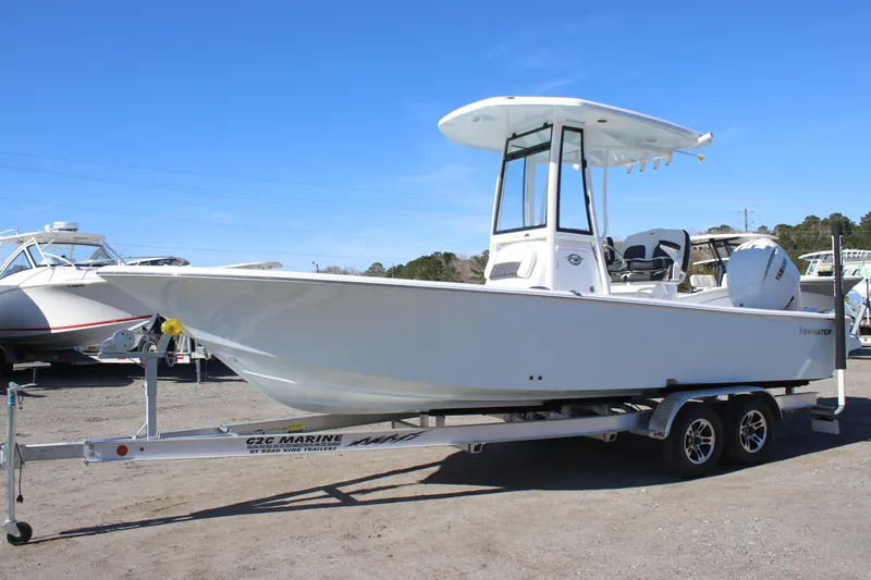 Slide: The Image of 2026 Tidewater 2300 Carolina Bay boat on trailer, displayed outdoors under clear blue sky. - 4