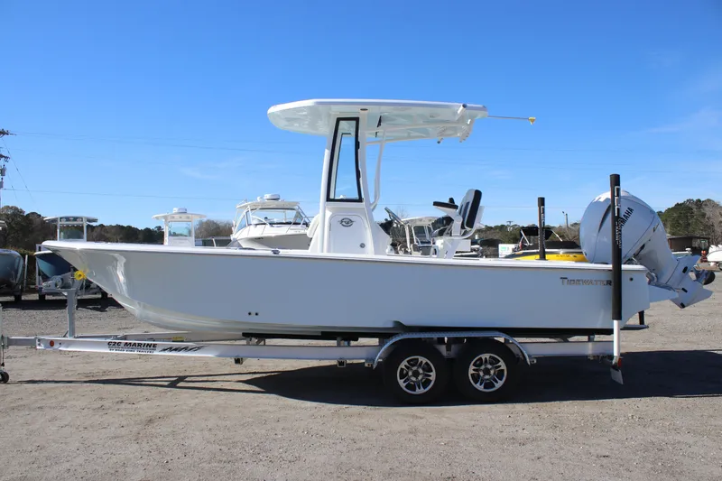 Slide: The Image of 2026 Tidewater 2300 Carolina Bay boat on trailer, parked outdoors under clear blue sky. - 5