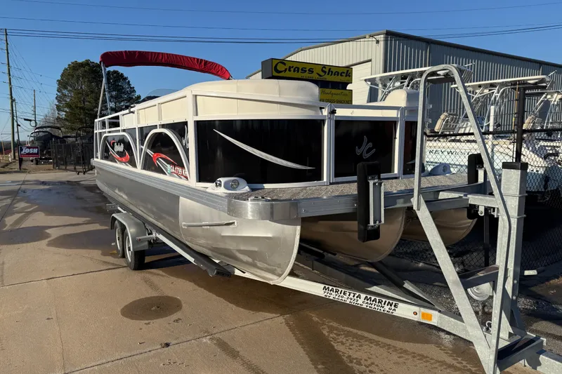 Slide: The Image of 2021 JC Spirit 221TT pontoon boat on trailer at marina. - 1