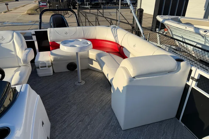 Slide: The Image of 2021 JC Spirit 221TT boat interior with white and red seating, round table, and cup holders. - 17