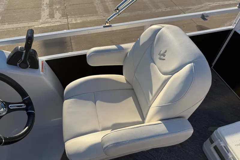 Slide: The Image of Captain's seat of 2021 JC Spirit 221TT boat with steering wheel and controls. - 27
