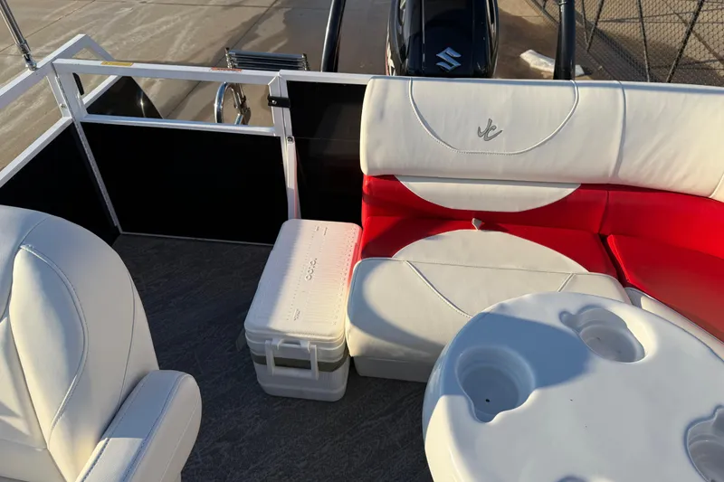 Slide: The Image of 2021 JC Spirit 221TT boat interior with white and red seating, cooler, and table. - 28