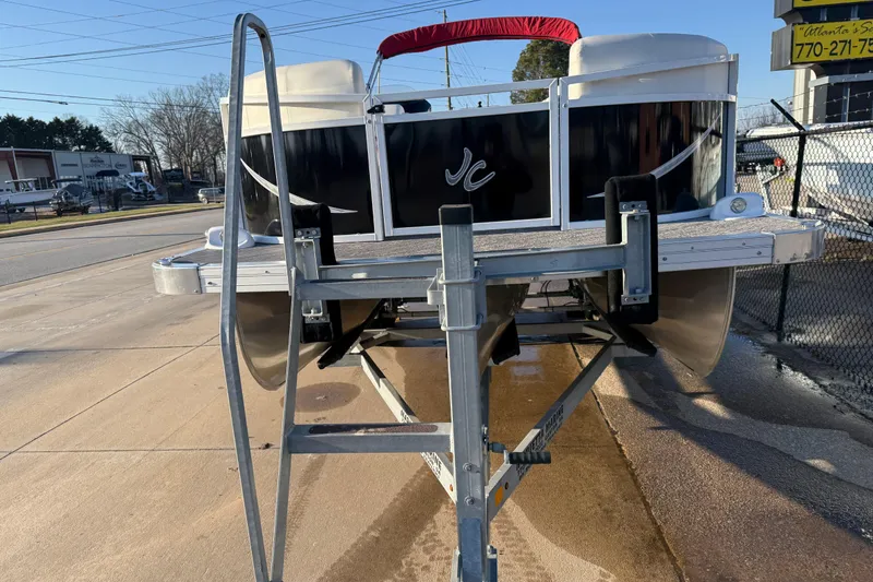 Slide: The Image of 2021 JC Spirit 221TT pontoon boat on trailer, parked outdoors. - 3