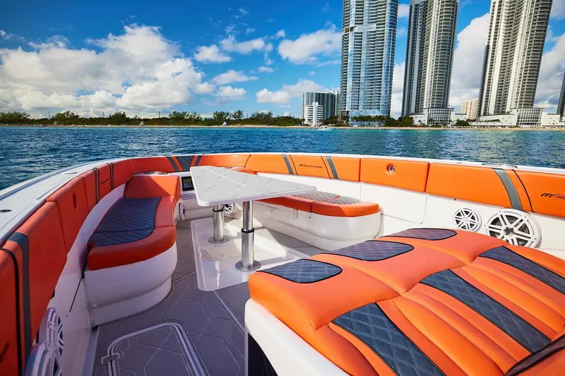Slide: The Image of Luxurious Midnight Express 43 Open boat with vibrant orange seating, city skyline in background. - 12