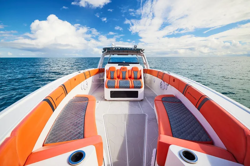 Slide: The Image of Midnight Express 43 Open boat with vibrant orange seating on open sea under blue sky. - 9