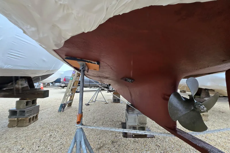 Slide: The Image of Bottom view of a 1982 SISU 26 boat, showing propeller and hull on stands. - 13