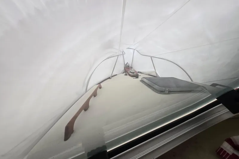 Slide: The Image of 1982 SISU 26 boat under protective cover, showcasing deck and hatch details. - 16