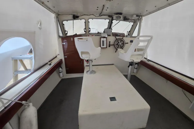 Slide: The Image of Interior of a 1982 SISU 26 boat with helm and seating area. - 26