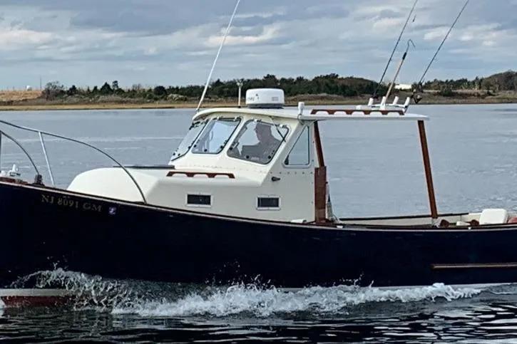 Slide: The Image of 1982 SISU 26 boat cruising on a calm lake under a cloudy sky. - 3