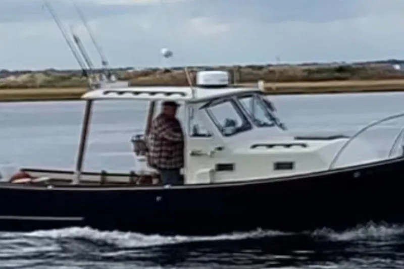 Slide: The Image of 1982 SISU 26 boat cruising on a calm waterway with a person onboard. - 4