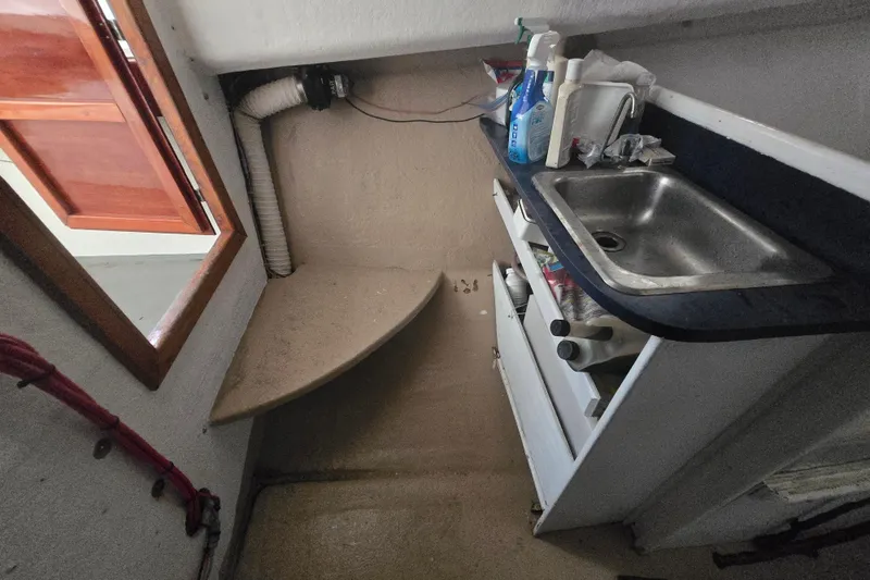 Slide: The Image of Compact kitchen area in a 1982 SISU 26 boat, featuring a sink and storage. - 7
