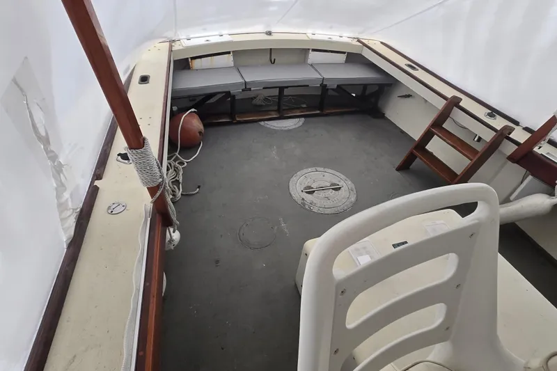 Slide: The Image of Interior of a 1982 SISU 26 boat, featuring seating and wooden elements. - 9