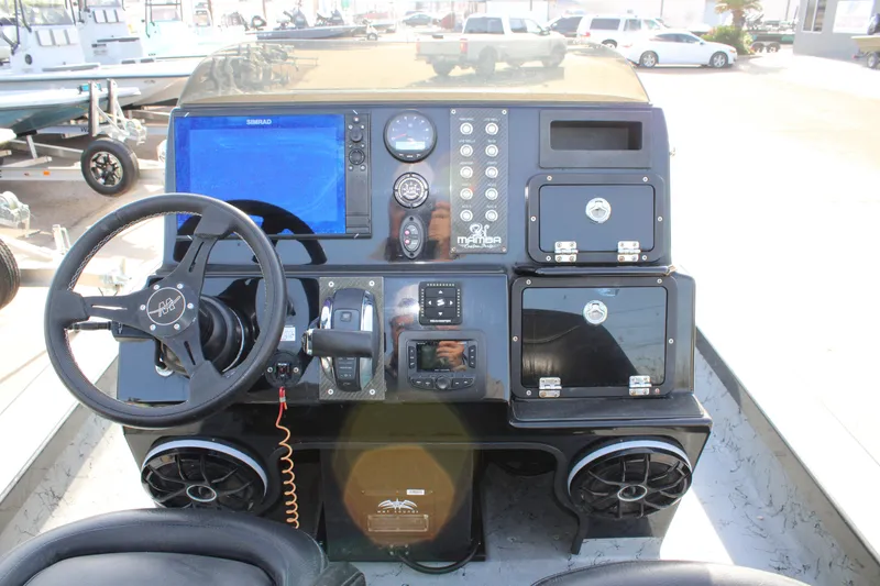 Slide: The Image of 2024 Mamba 24VX boat dashboard with steering wheel, controls, and storage compartments. - 15