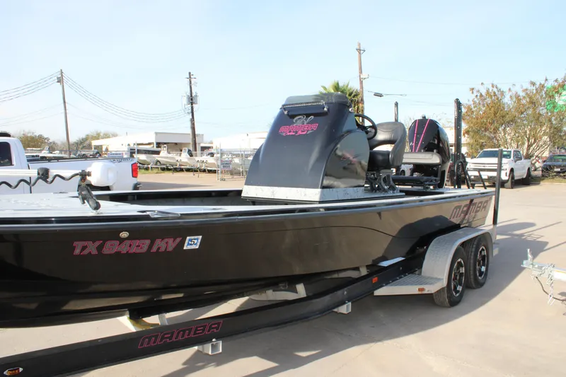 Slide: The Image of 2024 Mamba 24VX boat on trailer, black exterior, parked outdoors. - 16