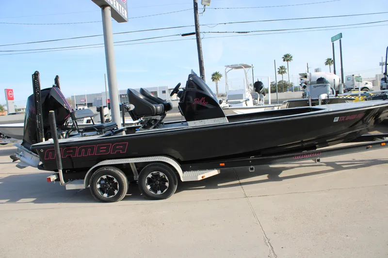 Slide: The Image of 2024 Mamba 24VX boat on trailer, sleek black design, parked outdoors. - 17